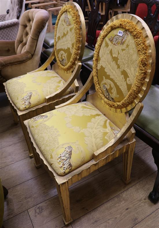 A pair of Italian side chairs upholstered with a yellow fabric printed with feathers, tigers and leopards